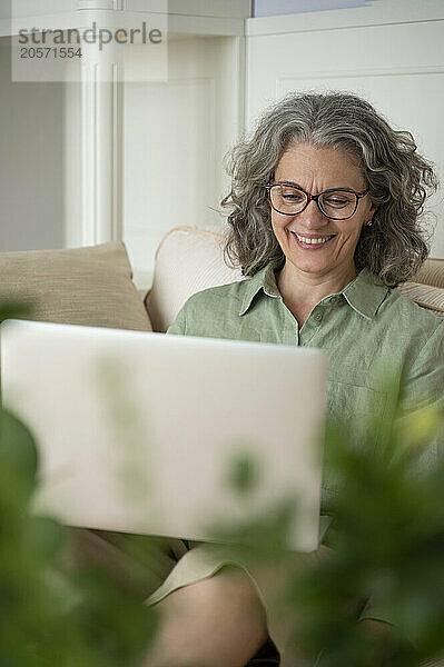 Happy businesswoman working on laptop at home