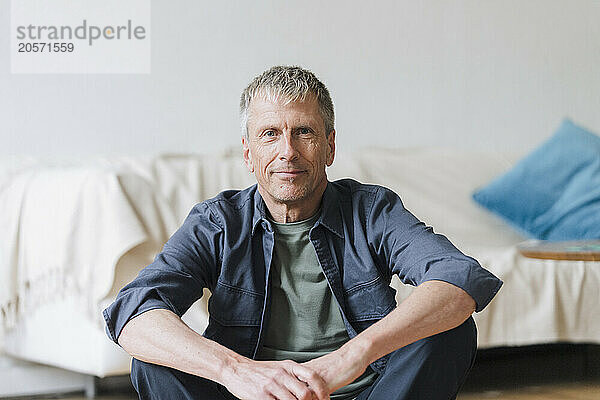 Confident senior man sitting living room at home