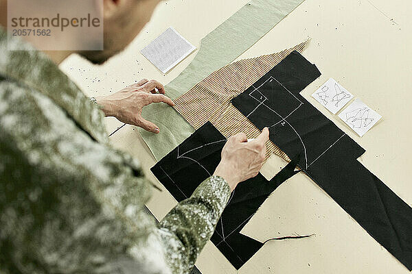 Fashion designer examining fabric samples at workshop