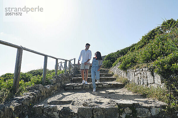 Boyfriend and girlfriend moving down from steps