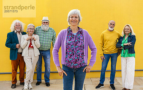 Confident mature woman with senior friends in background