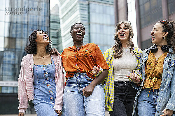 Happy female friends standing in city