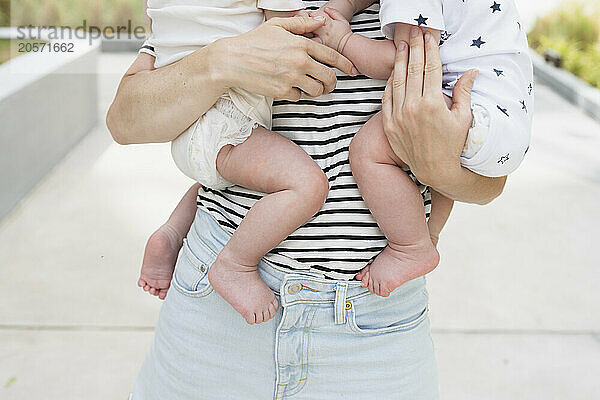 Mother standing in back yard and carrying sons