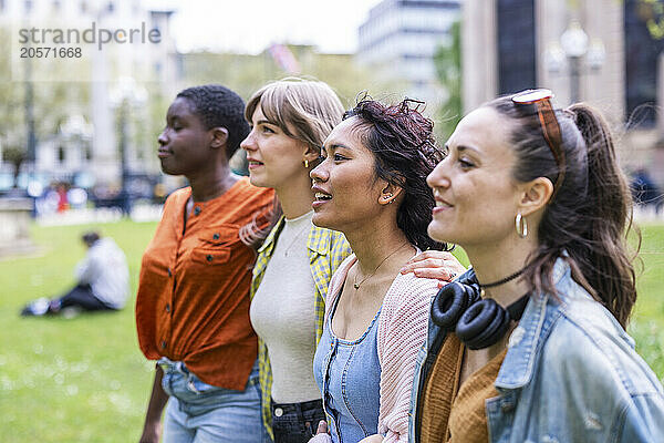 Multiracial friends walking side by side at park