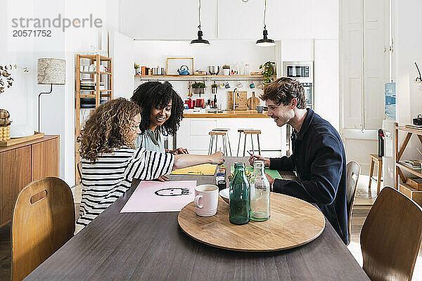 Family sitting at table drawing and painting together