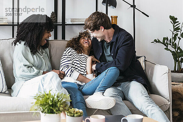 Laughing family having fun sitting on couch