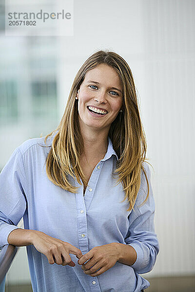 Happy young businesswoman standing at airport