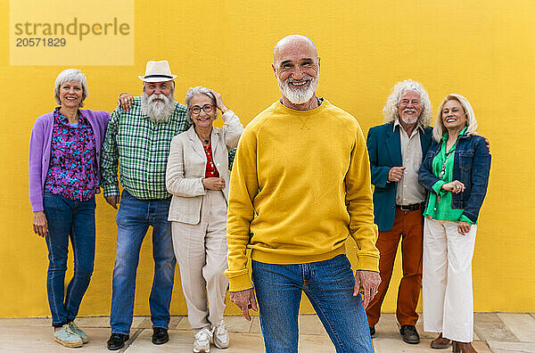 Happy elderly man with friends in background