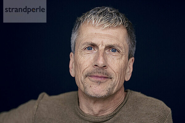 Senior man with wrinkles against black background