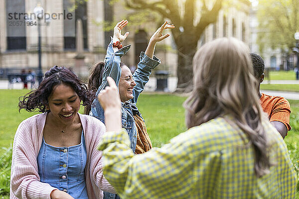 Carefree multiracial female friends dancing at park