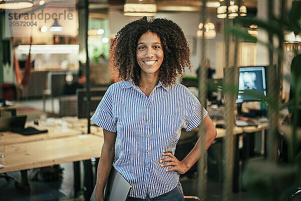 Young businesswoman with curly hair standing at shop