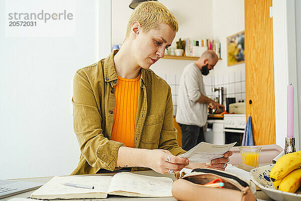 Freelancer reading document sitting at home office