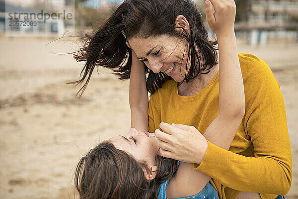 Cheerful mother enjoying with daughter at beach