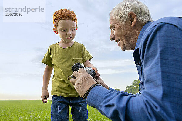 Senior man shows his grandson old camera