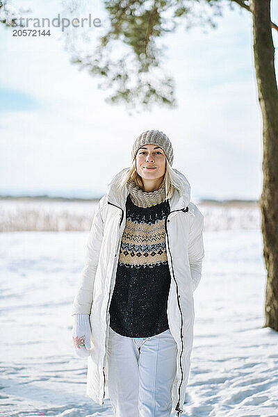 Beautiful woman in warm clothes walking on snow