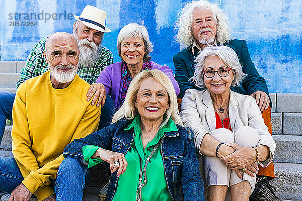 Happy men and women sitting together on steps