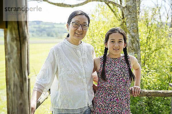 Smiling mother and daughter standing together