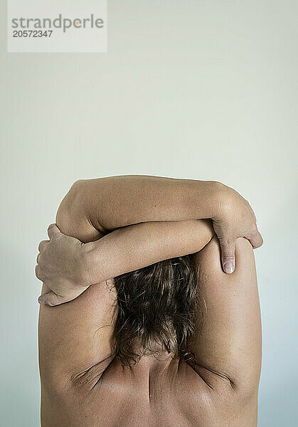 Mature woman with arms crossed in front of wall