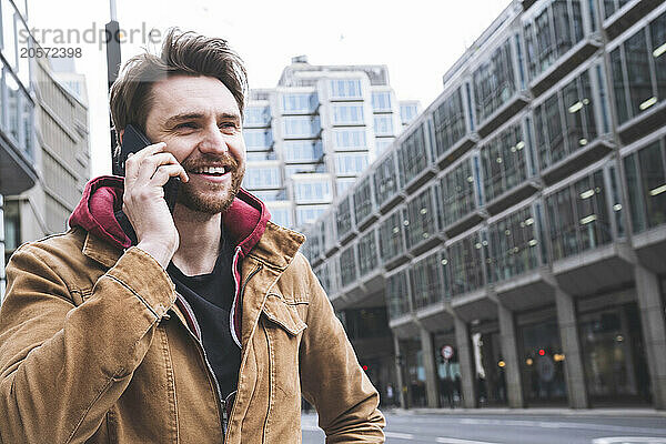 Handsome man talking on smart phone at street