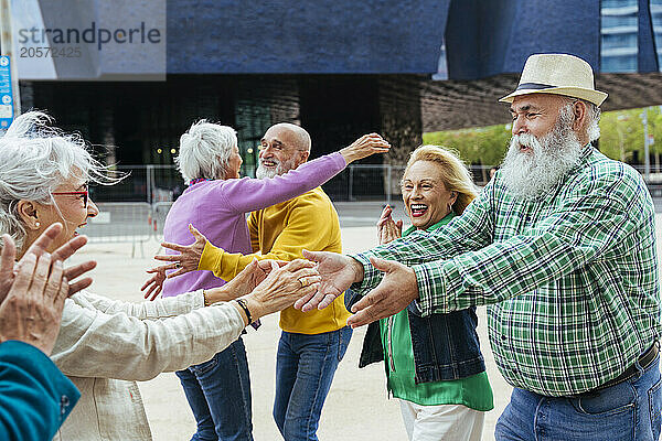 Happy elderly friends greeting each other on street