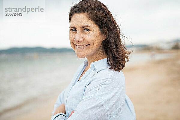 Smiling woman standing at beach