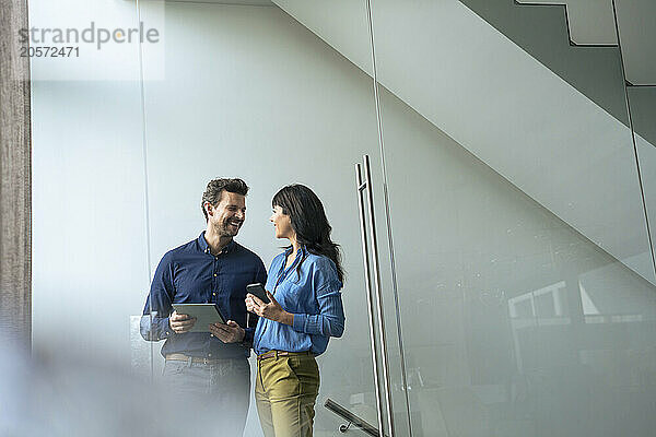 Smiling businessman talking to businesswoman at home office