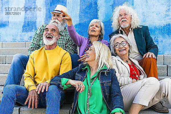 Woman pointing to friends sitting on steps