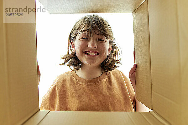 Happy girl looking into cardboard box