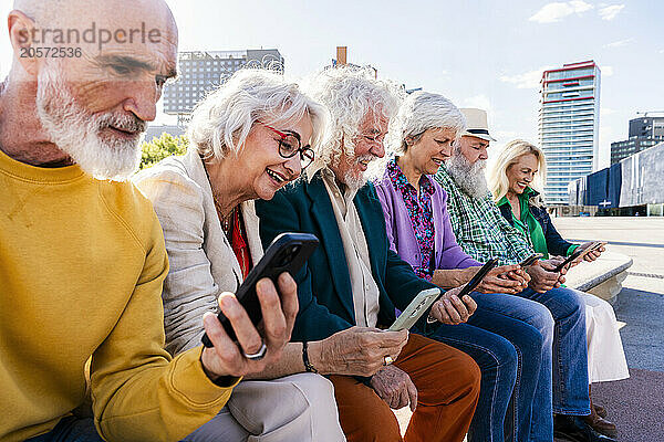 Men and women using mobile phones sitting together