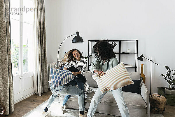 Lively family having fun with a pillow fight at home