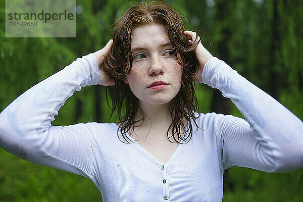 Thoughtful young woman with hand in hair