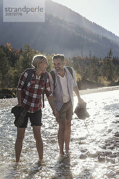 Happy couple standing in river on weekend