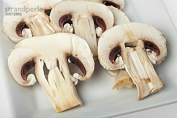 Slices champignon mushrooms on white background