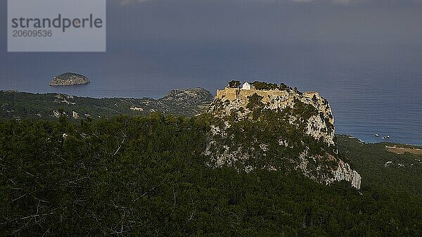 A small castle on a high rock with dense forests and views of the sea and a small island  Kastro Monolithou  Monolithos Castle  rock castle  Monolithos village  Rhodes  Dodecanese  Greek Islands  Greece  Europe