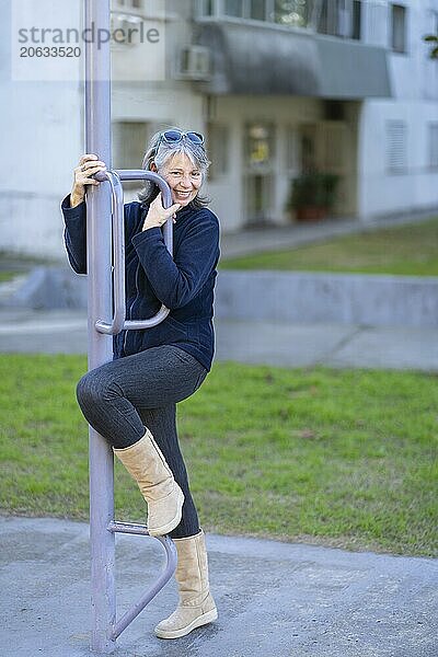 Woman in her sixties doing exercises in the park. Happy expression. Vitality concept