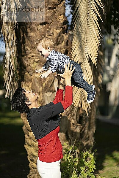 Mother playing toss her baby in the air