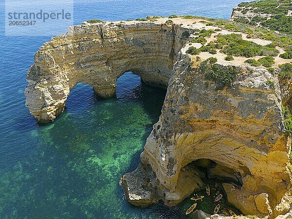 Large rock formations with natural arches on the coast  near water with canoes  aerial view  Praia da Marinha  double rock arch  Lagoa  Rocky Algarve  Algarve  Portugal  Europe