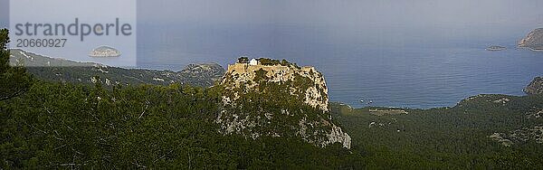 Sweeping panoramic views of wooded hills and a ruined castle on the coast with islands  Kastro Monolithou  Monolithos Castle  rock castle  Monolithos village  Rhodes  Dodecanese  Greek Islands  Greece  Europe