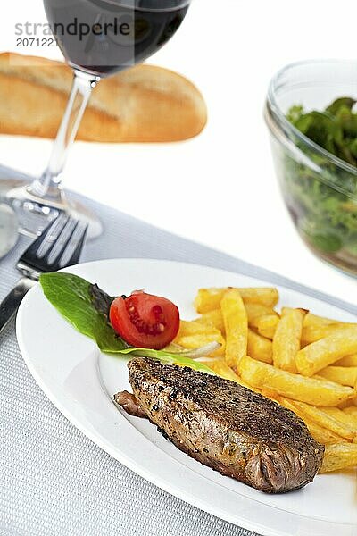 Closeup of a beef steak with french fries on a white background