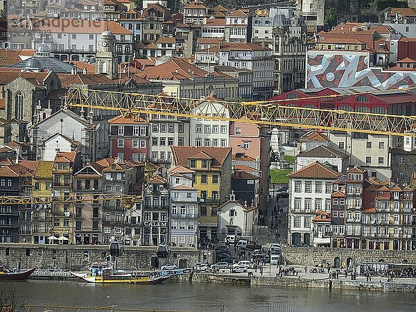 View of the city with many buildings  river and a large yellow crane  Porto  Douro  Portugal  Europe