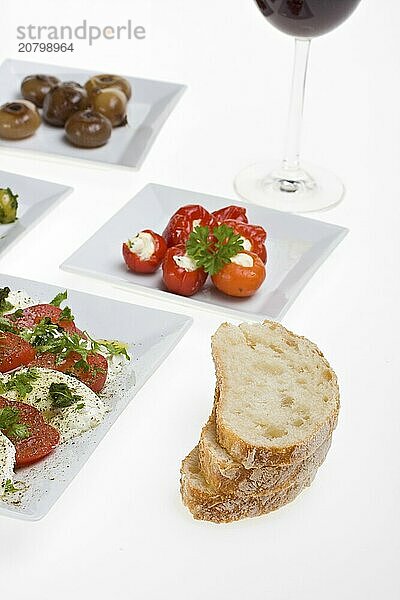 Antipasti misti and bread on white plates