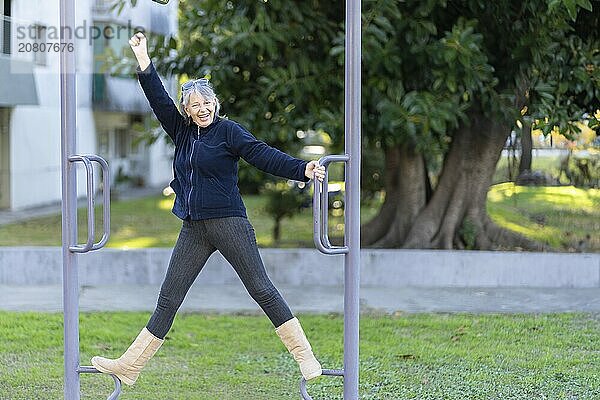 Woman in her sixties doing exercises in the park. Happy expression. Vitality concept