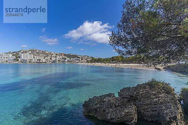 View of rocky shoreline by turquoise sea and Santa Ponsa  Majorca  Balearic Islands  Spain  Mediterranean  Europe