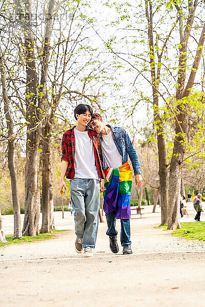 Vertical full length photo of a Romantic gay couple strolling in a park