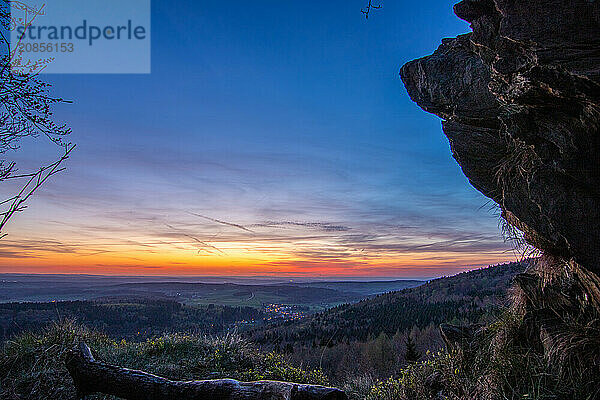 Panorama of a romantic landscape at sunset in the evening light. beautiful spring landscape in the mountains. Lawn and rolling hills. View from a cliff to the horizon. The Great Peak  Hesse  Germany  Europe