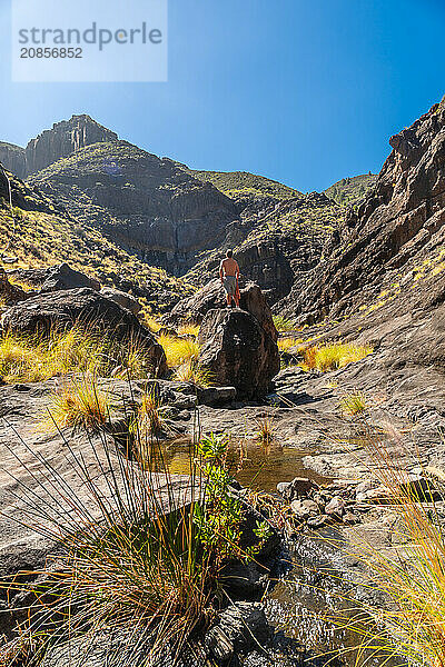 A hiker on the river on the climb to Charco Azul in the Podemos to Agaete in Gran Canaria  Canary Islands