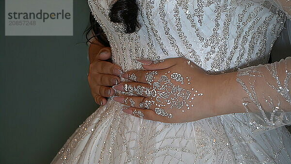 Bride in a wedding dress with a pattern on her hands