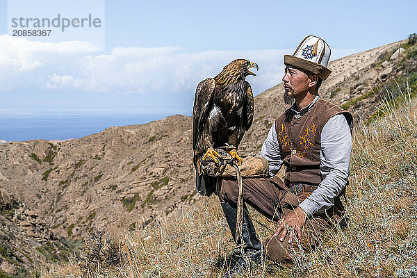 Traditional Kyrgyz eagle hunter with eagle in the mountains  hunting  near Bokonbayevo  Issyk Kul region  Kyrgyzstan  Asia