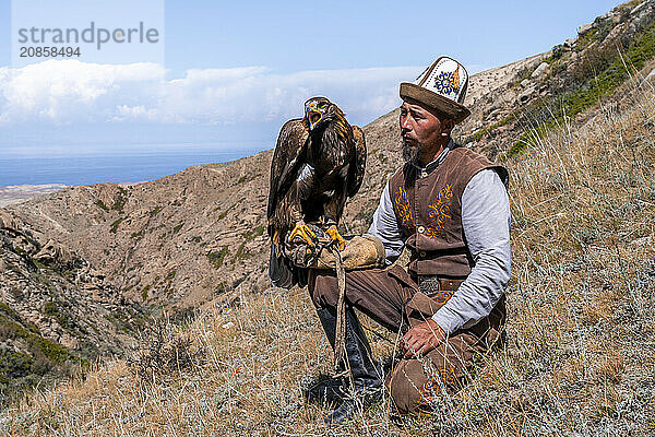 Traditional Kyrgyz eagle hunter with eagle in the mountains  hunting  near Bokonbayevo  Issyk Kul region  Kyrgyzstan  Asia