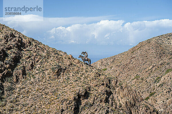 Traditional Kyrgyz eagle hunter riding with eagle in the mountains  hunting on horseback  near Bokonbayevo  Issyk Kul region  Kyrgyzstan  Asia